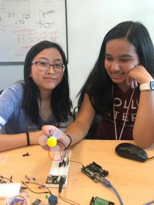 Two female engineering students programming a fan on an arduino board at Try Engineering Summer Institute for high school students
